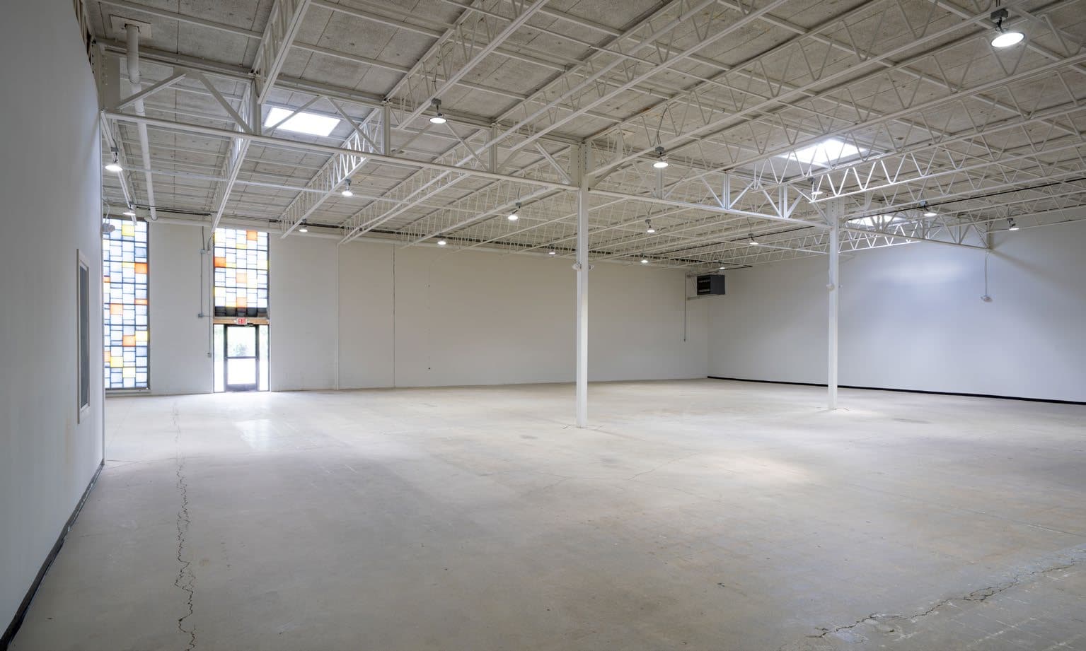 Wide polished concrete warehouse floor with skylights